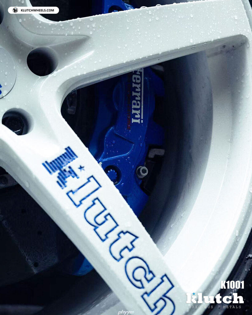 Close-up of Klutch K1001 forged wheel face and blue brake caliper